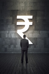The image shows a businessman standing in front of a large illuminated Indian rupee symbol (₹), symbolizing financial decisions, currency strength, and economic power within the context of the Indian 