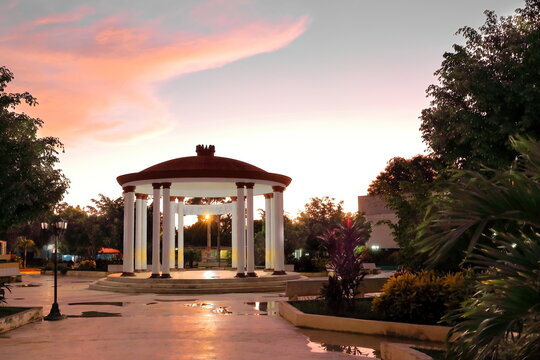 Parque Ricardo Cespedes Park at dusk with a roofed central pavilion in the form of a circular colonnade -monopteros or cyclostyle-. Niquero-Cuba-392