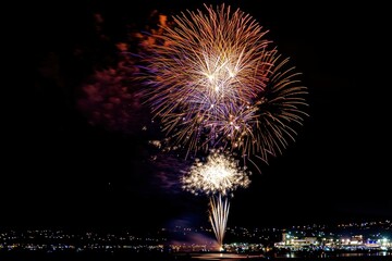 Fireworks on the dark sky background. Colorful fireworks from Loto Quebec in Quebec, Canada. Abstract colored firework background with free space for text. fireworks light up the night sky , ai
