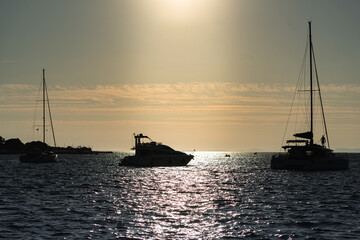 sunset in the sea with sailboat