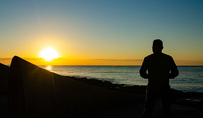 siluetas al amanecer en la costa. 