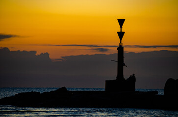 siluetas al amanecer en la costa. 