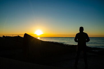siluetas al amanecer en la costa. 