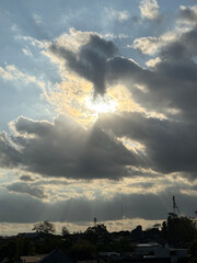 a dramatic sky with large, dark clouds that are illuminated by the sun, creating a striking contrast between light and shadow