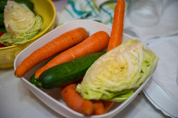 Carrots, cucumbers and cabbage in a plastic kitchen bowl