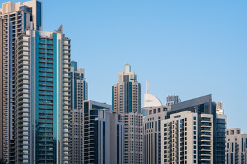 Large residential concrete tower buildings in city, huge skyscrapers in Dubai, Arab architectural design