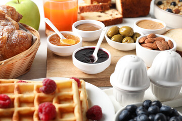 Different meals served for breakfast on white table, closeup. Buffet menu