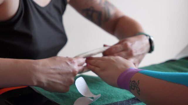 A woman is wrapping a bandage around a woman's arm.