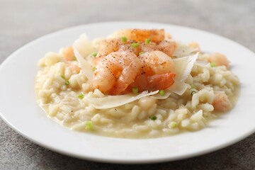 Delicious risotto with shrimps and cheese on grey table, closeup