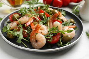 Delicious shrimp salad with tomato and olives on table, closeup