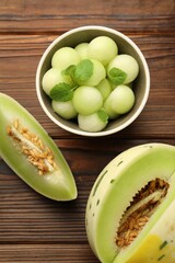 Melon balls in bowl and fresh fruit on wooden table, flat lay