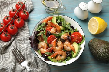 Delicious shrimp salad and ingredients on light blue wooden table, flat lay