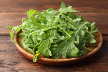 Fresh green arugula leaves on wooden table, closeup