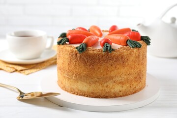 Delicious carrot cake, server and tea on white wooden table, closeup