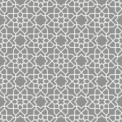 Seamless Islamic pattern consisting of interlocking white lines on a gray background. Suitable for various creative projects or decorative elements.