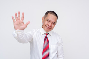 Friendly middle aged office male professional politely requesting to stop an activity with his hand in a non-aggressive way. Set against a white background.