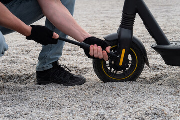 Obraz premium Pumping up the wheel of an electric scooter