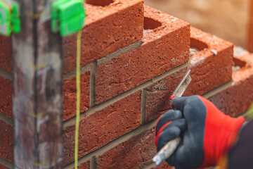 Skilled Artisan Lays Bricks for a Sturdy Wall During Sunny Afternoon Construction Work