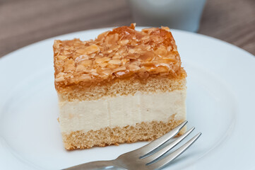 ein Stück Bienenstich auf einem Teller mit einer Gabel
