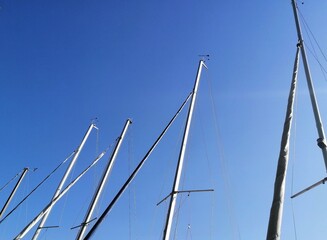 Masts of sailboats against clear blue sky
