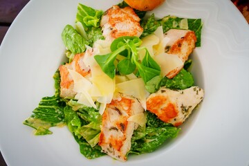 This fresh salad features grilled chicken breast on a bed of crisp lettuce, juicy cherry tomatoes, crunchy cucumbers, and colorful carrots, all drizzled with zesty vinaigrette for a nutritious meal.