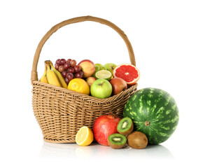 Many different fresh fruits in wicker basket isolated on white