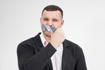 businessman is removing a piece of tape that has been covering his mouth