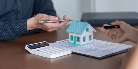 Discussing real estate contract details with a house model