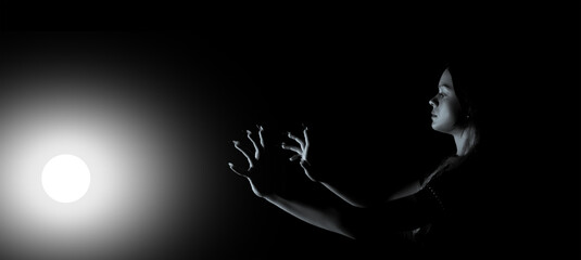 Creative image of a girl in the dark with one light source