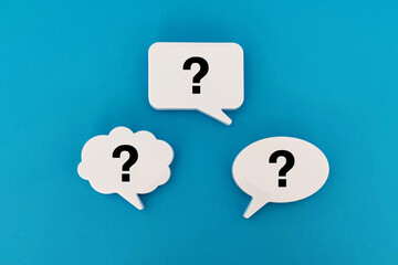 Question marks with speech bubbles on blue background