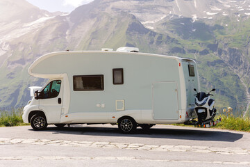 Scenic view big modern white family rv camper van vehicle open bonnet stay roadside Europe highway road alpine pass mountain sunny summer day. Rving motorhome lifestyle travel adventure tourism