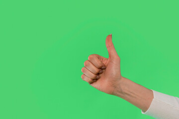 A Hand Giving a Thumbs up Against a Vibrant Green Background in a Cheerful Display of Approval