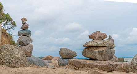 Pyramid of pebbles on the beach with blue sky