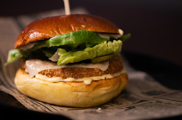 Chiken cheese burger with bacon on black background