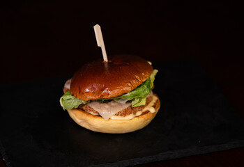 Chiken cheese burger with bacon on black background