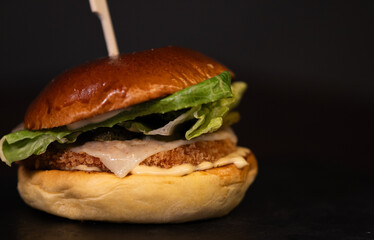 Chiken cheese burger with bacon on black background