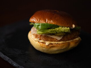 Chiken cheese burger with bacon on black background