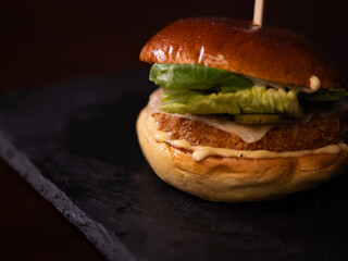 Chiken cheese burger with bacon on black background
