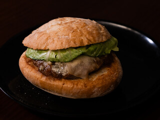 Cheese burger with bacon on black background