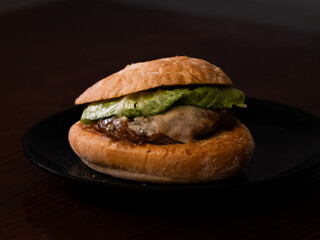 Cheese burger with bacon on black background