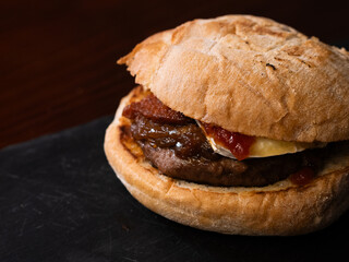 Cheese burger with bacon on black background
