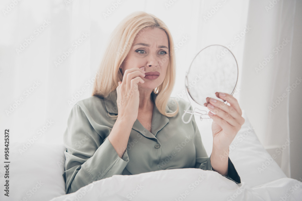 Wall mural Photo of pretty young woman look mirror sullen face silky pajama white interior bedroom apartment indoors