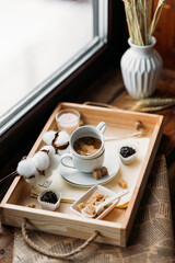 morning coffee in a white cup, espresso, americano, breakfast on a wooden tray on the windowsill, brown sugar, candy, coffee in bed, cotton flowers, candles, romance