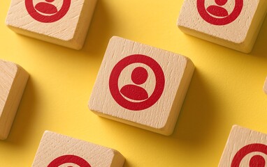 Colorful wooden blocks with a red user icon on a vibrant yellow background, representing community and connection.