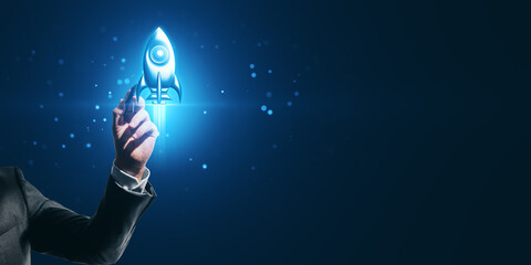 Close up of man hand pointing at creative glowing rocket spaceship hologram on dark blue background with mock up place. Start up, launch, social media, network and connection concept.