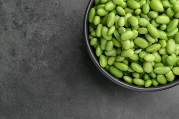 Raw green edamame soybeans on grey table, top view. Space for text