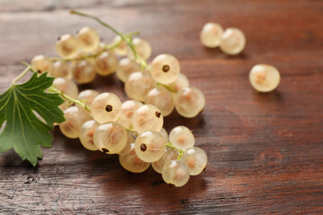 Fresh white currant berries and green leaf on wooden table, closeup
