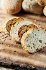 Homemade bread, bread with wheat and spelled flour. Texture of bread sliced and cut in half on a wooden board. Crispy sandwich bread