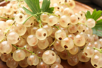 Fresh white currant berries and green leaves on table, closeup
