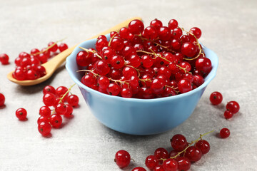 Fresh red currants on light grey table, closeup